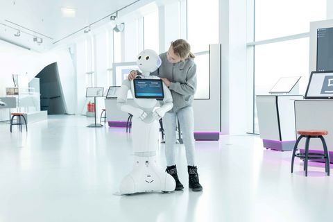 Man sieht ein Kind mit einem Roboter in der Ausstellung des Science Center phaeno