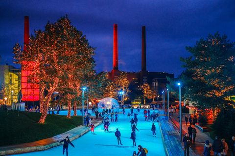 Winter ind er Autostadt in Wolfsburg: Man sieht die weihnachtlich beleuchtete Parklandschaft, im Vordergrund ist eine Eislauffläche zu sehen.